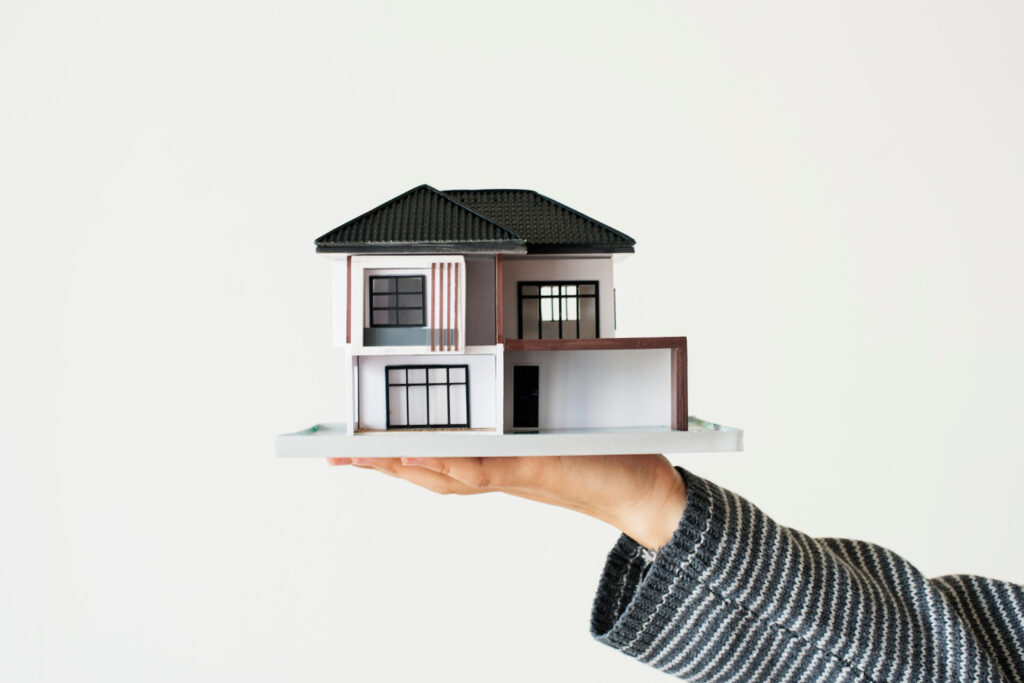 mini-sized model house standing on the palm of the hand